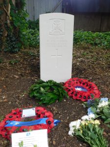Photo of Private Harris headstone, wreaths and flowers