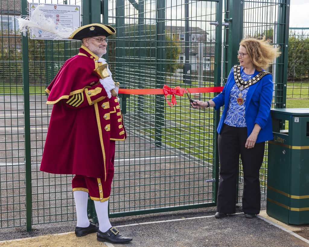 Photo of Mayor Councillor Fiona Holness and Town Crier Owen Collier cutting the ribbon to open the Multi Use Sports Area
