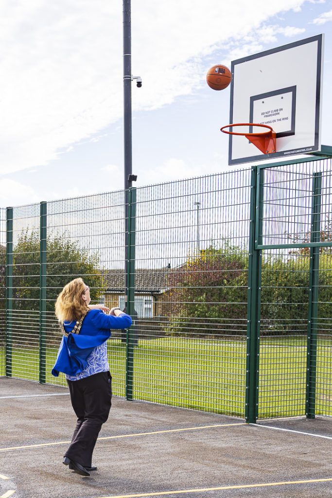 Mayor Councillor Fiona Holness throwing a ball through the basketball hoop